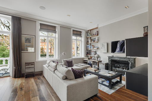 Modern living room with grey sofa, fireplace in this luxury property for sale in London ($4,680,083)