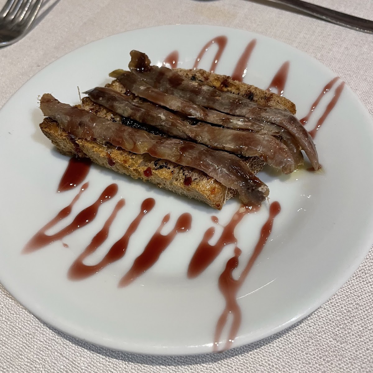 Anchoa del Cantábrico con ajo negro (fish)