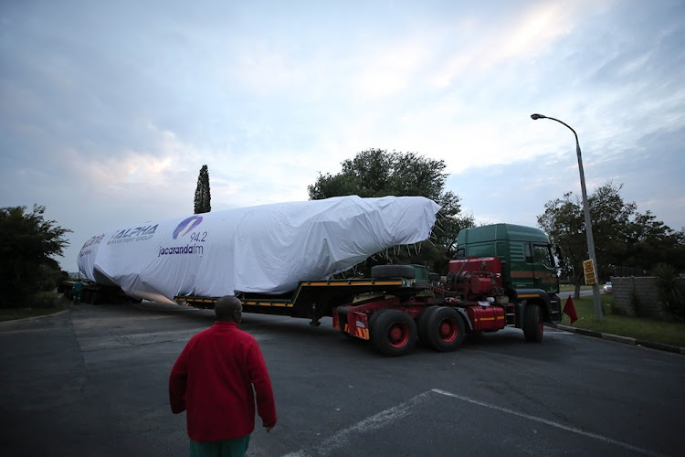 Crew members inspect the Boeing 737 ahead of its transport to Fourways, Johannesburg on February 26 2018.