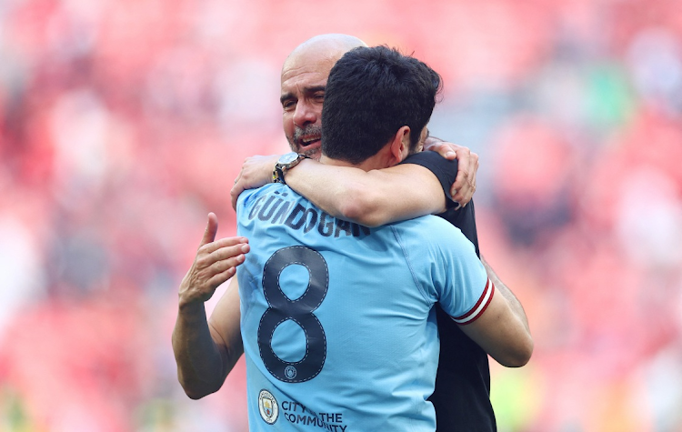 Manchester City manager Pep Guardiola embraces double scorer Ilkay Gundogan after winning the FA Cup final against Manchester United at Wembley Stadium in London on June 3 2023.