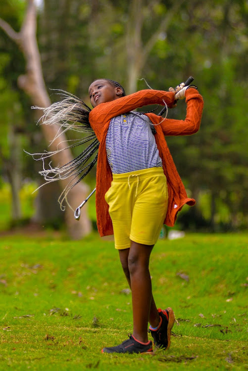 A budding golfer tees off at the NCBA sponsored Kids golf tournament at the Royal Nairobi Golf Club