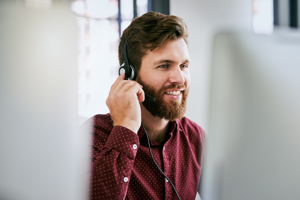 Businessman with headset using a computer and call handling skills