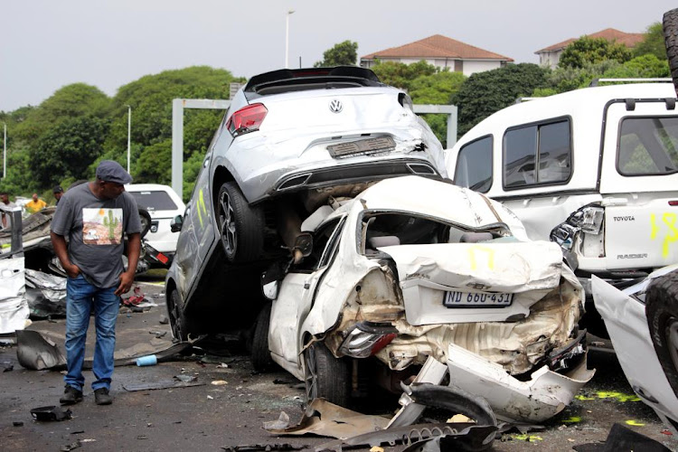 A bystander examines the damage caused by a truck that ploughed into 46 cars.