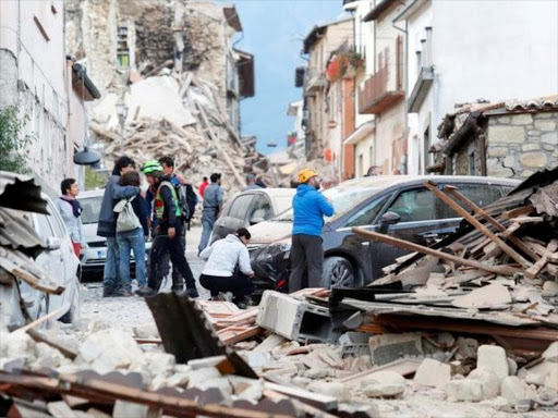 People stand along a road following a quake in Amatrice, central Italy, August 24, 2016. REUTERS/Remo Casilli