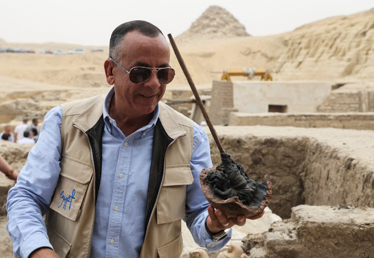 Mostafa Waziri, secretary-general of Egypt's Supreme Council of Antiquities talks to the media and holds a tool that was found next to an embalming workshop site for humans at the newly discovered site where embalming workshops for humans and animals along with two tombs and a collection of artefacts were also found, near Egypt's Saqqara necropolis, in Giza, Egypt May 27, 2023.
