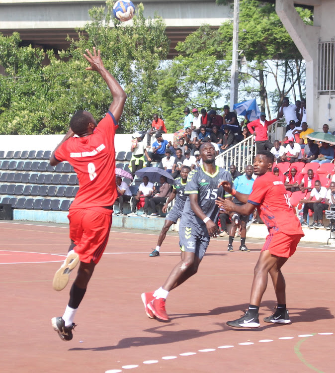 Rwanda's Kayisamehe Hyles of Rwandese side Gicumbi (L) stretches to block an aerial pass by Kenya's NCPB William Malut during the East and Central Africa Handball Federation Championships at Nyayo Stadium on December 3