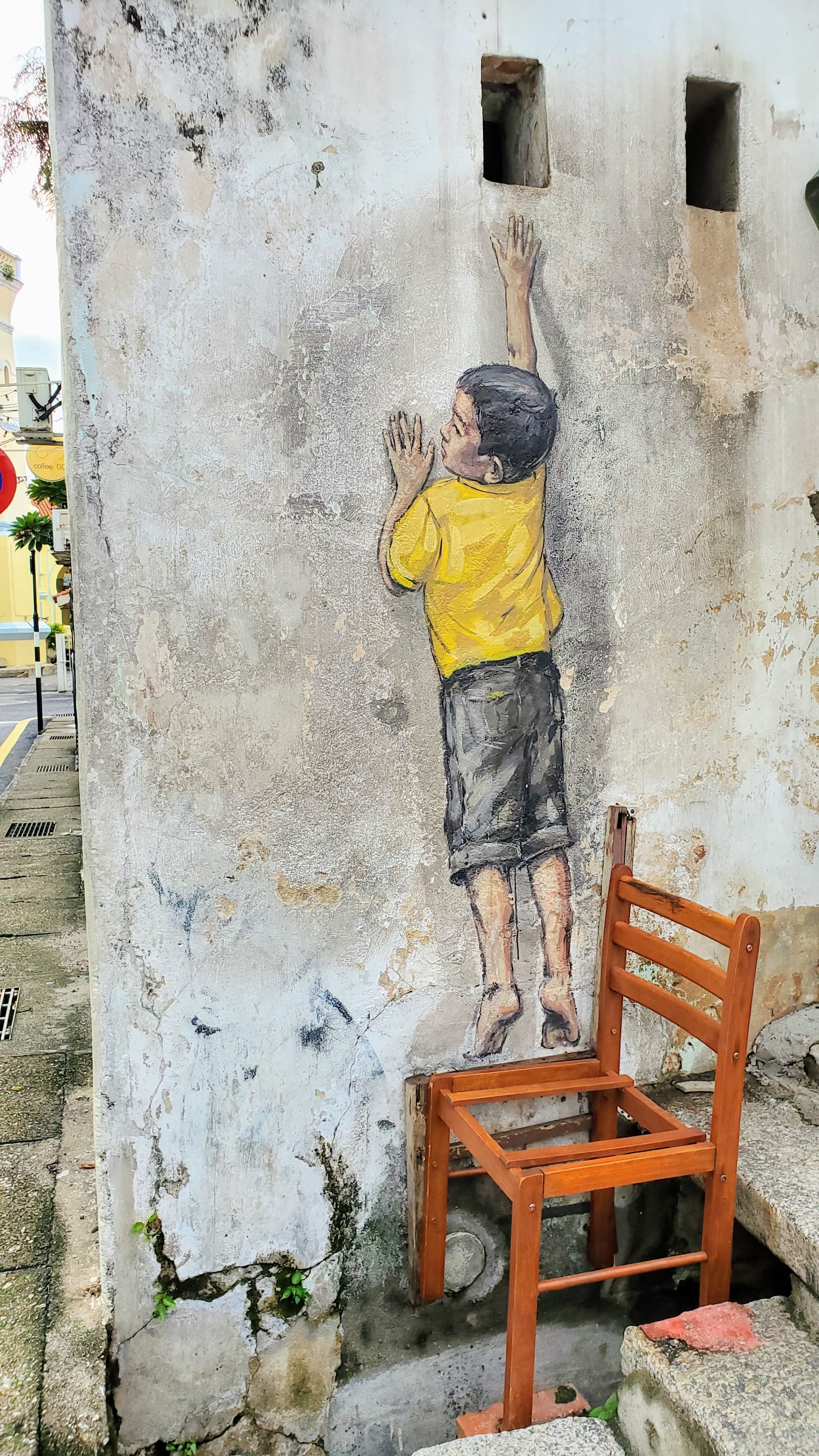 Tips on visiting George Town Street Art: the most famous street art are the ones from Ernest Zacharevic commissioned as part of a Mirrors George Town street art initiative and which are now considered iconic to George Town. This one is Boy on a Chair