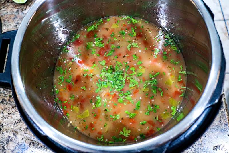 Chicken Broth, White Chili Seasoning, Rotel, Chopped Green Chiles, Garlic, Lime Juice, And Cilantro In Slow Cooker.