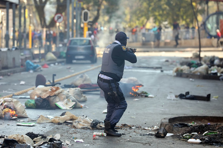 Members of the police face off with protestors in the Johannesburg CBD.