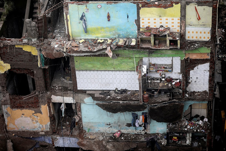 A portion of a residential building collapsed, leaving exposed walls and household items still intact, in Mumbai.