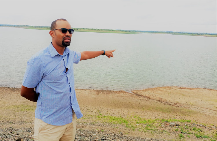 Tana River Development Authority CEO Liban Roba shows the extend of the waters of the Masinga dam along Tana River in Machakos during a tour on Wednesday, April 27.