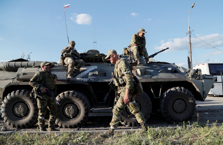 Service members of pro-Russian troops wait before the expected evacuation of wounded Ukrainian soldiers from the besieged Azovstal steel mill in the course of Ukraine-Russia conflict in Mariupol, Ukraine May 16, 2022.