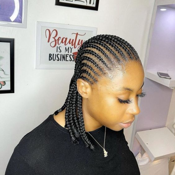 lady wearing short cornrows with a black top