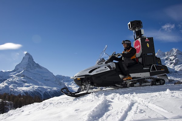 Un homme traverse les montagnes valaisannes à bord d'une motoneige équipée d'une caméra Google Maps. En arrière-plan, on voit le Cervin.
