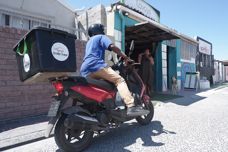 Take-away pizza, ordered by app, is delivered by motorcycle.