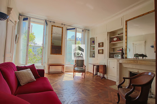 Property purchase in Paris 10ème (75010) - living room with red sofa and old parquet floor