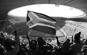 Fans hold up a South African flag before the 2010 World Cup opening match between South Africa and Mexico at Soccer City stadium in Johannesburg June 11, 2010. REUTERS/Kim Kyung-Hoon