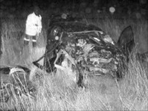 LIVES WASTED: An emergency worker inspects the BMW in which three youngsters lost their lives. Five of their friends are in a critical condition in hospital. Two pastors, travelling in the opposite direction also died. Pic. Matshube Mfoloe. © Unknown.