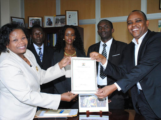 Registrar of political Parties Lucy Ndungu hands certificate of Double Double Coalition Party to Jaffer Isaak as legal officers standby at the head office Sep 16 2015. photo/PATRICK VIDIJA