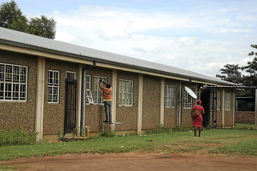 A man replaces the windows at Mmametlhake Seconday School after Derrick Bopape smashed them with bricks.