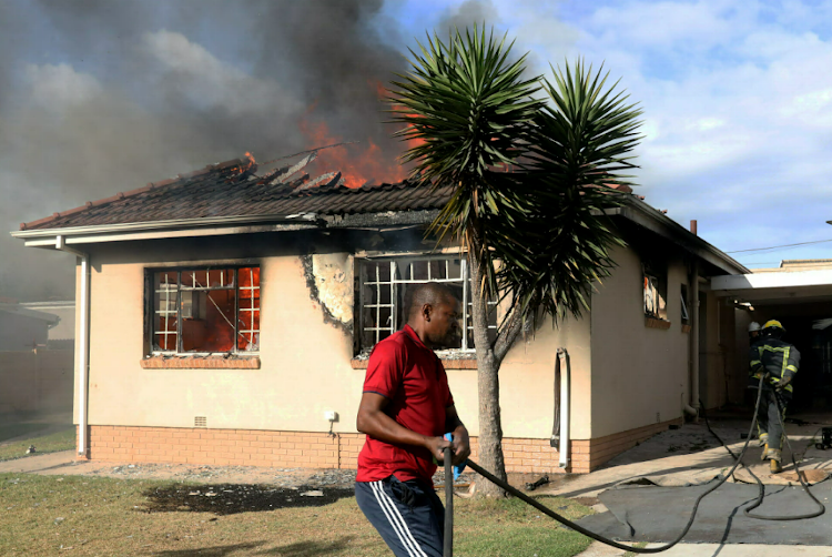 Firefighters douse the fire at a house in Woolhope Road, Westering, which was gutted.