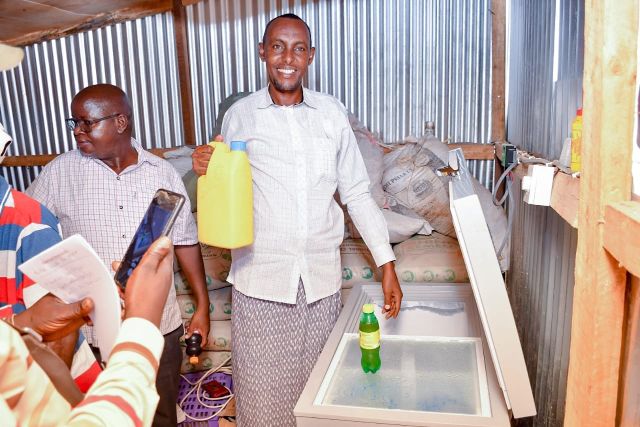 Gele Mohamed of Kasha youth for peace displays camel milk stored in a freezer donated by ASDSP to promote milk value chain producers.