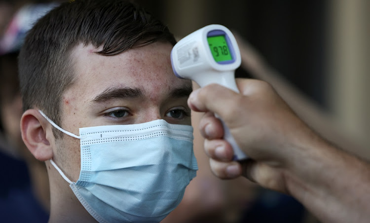 David Rooney, a student at Michigan's Clarkston Junior High School, gets a temperature check before boarding a tour bus during his 8th grade trip to Washington, in Sterling, VA, U.S., U.S., June 18, 2021.