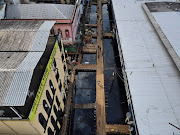 An aerial view of a street flooded by water from the Negro river, where people walk over wooden walkways installed by the city hall in downtown of Manaus, in Amazonas State, Brazil May 17, 2021.  