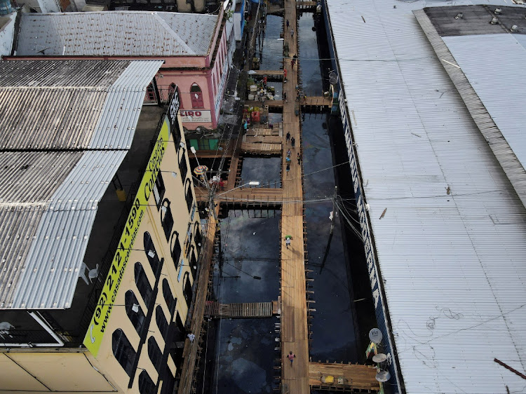 An aerial view of a street flooded by water from the Negro river, where people walk over wooden walkways installed by the city hall in downtown of Manaus, in Amazonas State, Brazil May 17, 2021.