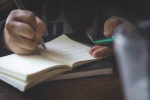 Man writing in a notebook.