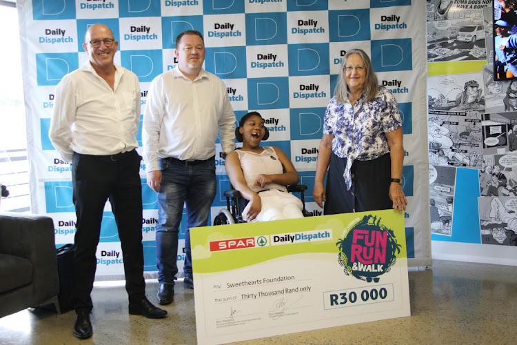 Spar's purchasing manager Alan Stapleton, Daily Dispatch general manger Ryan Megaw, wheelchair reciepient Litha Soldati and Glynis Butler of Sweethearts foundation during the wheelchair handover at the Dispatch offices on Tuesday.