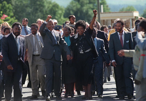 South African National Congress (ANC) leader Nelson Mandela (c) and his then-wife Winnie raise their fists 11 February 1990 in Paarl to salute cheering crowd upon Mandela's release from Victor Verster prison.