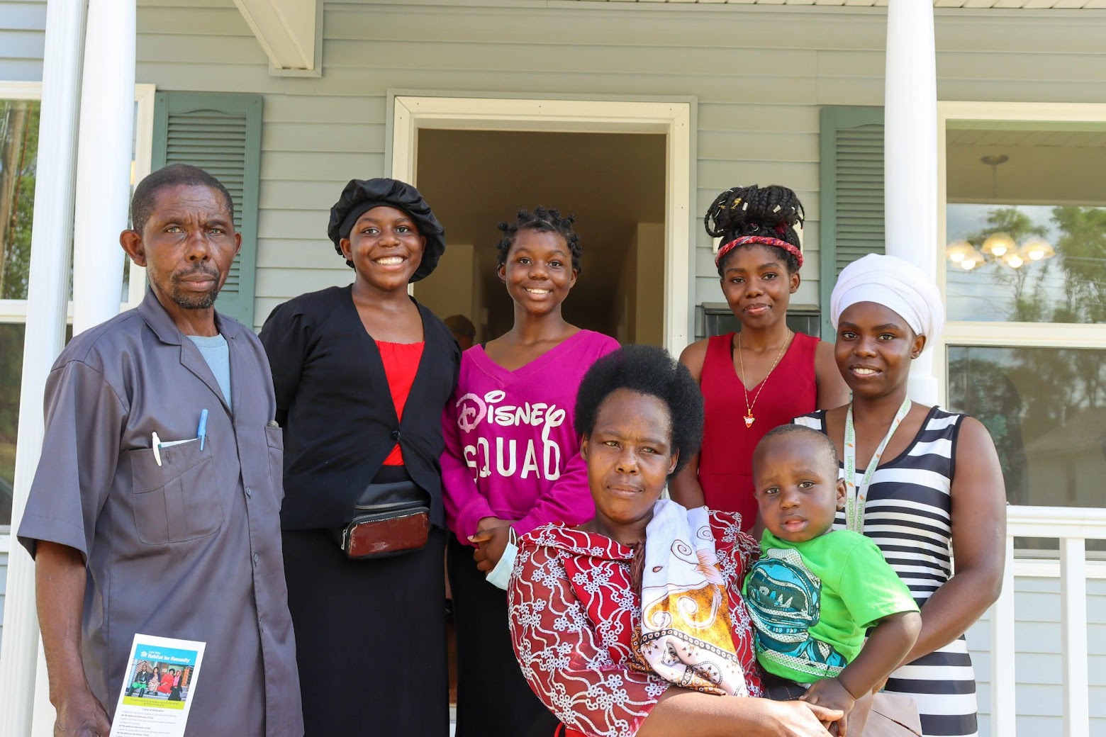 A Habitat family smiles in front of their new home