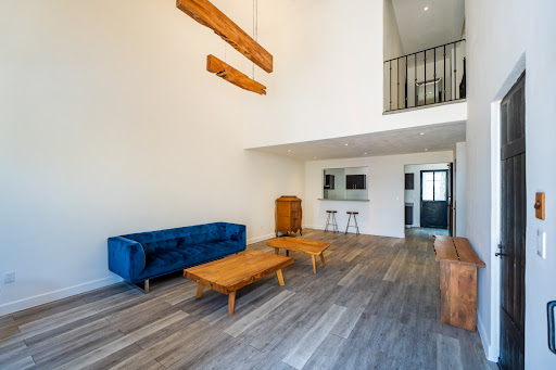 Modern living room with blue sofa and mezzanine - Buy this luxury property in San Miguel de Allende, 3 bedrooms