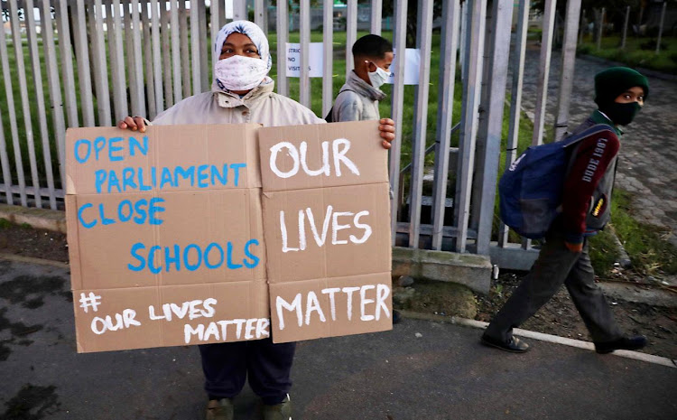 Cape Flats resident Farieda Abrahams from Hanover Park, Western Cape stands outside the gate of her son's school protesting agains the reopening of schools as Covid-19 infections are on a rapid rise on July 7 2020.