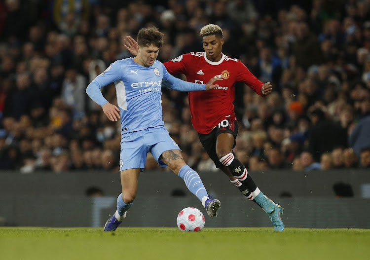 Manchester City's John Stones in action with Manchester United's Marcus Rashford.