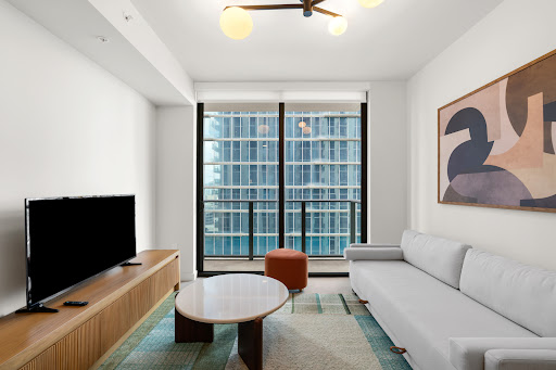 Modern living room with white sofa and city view in this luxury property for sale in Miami ($565,000)