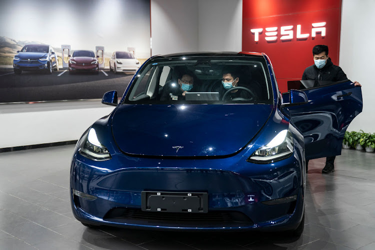 An employee assists customers in a Tesla showroom in Wuhan, Hubei Province, China.