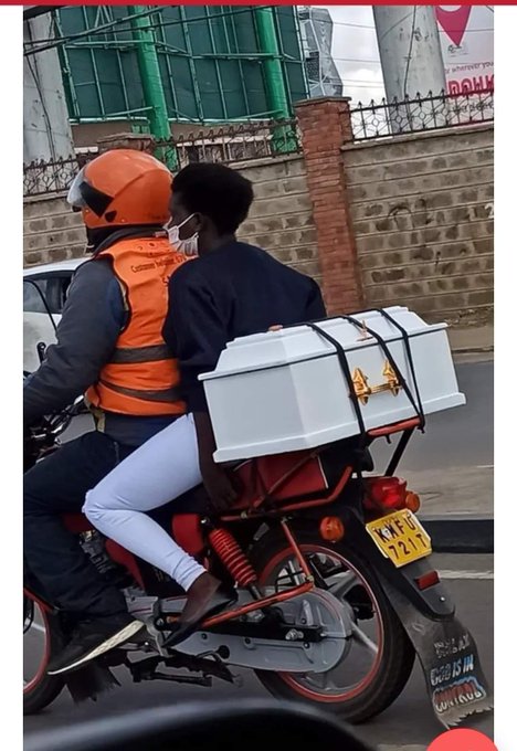 A woman on a boda boda while ferrying a child-sized coffin