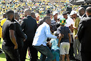 Bodyguards in black suits surround Duduzane Zuma as he embraces two boys during the ANC 108th anniversary event in Kimberley last month. He represented his father at the celebration. 