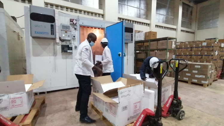 Workers store the Covid-19 vaccine at the Kemsa warehouse in Kisumu.