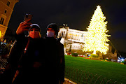 People take a selfie at Piazza Venezia with a Christmas tree in the background, amid the coronavirus disease (Covid-19) outbreak, in Rome, Italy December 9, 2020. 