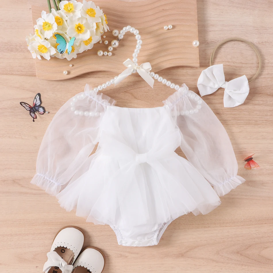 Barboteuse bébé manches longues avec nœud et jupe, idéale pour nouveau-nés. Confort et style pour votre bébé. Un look adorable.