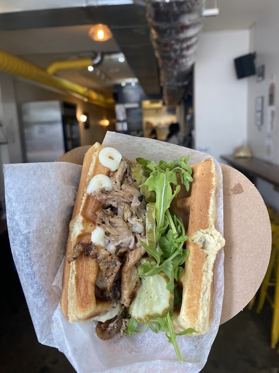 Pictured is our GF Peach BBQ pork belly special! 🤤 Our mouthwatering Peach bbq glaze homemade from real local peaches, topped with Mayo, pickles, and arugula. Available 8/2-8/21