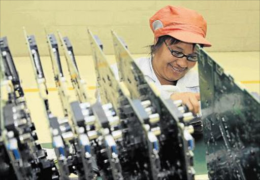 GAINFULLY EMPLOYED: A Hisense factory worker concentrates on the television production line last year at the Hisense factory in Atlantis on August 24, 2015 in the Western Cape. The Atlantis facility has the capacity to manufacture 1200 fridges and 1700 televisions per day. Economists are predicting that South Africa’s manufacturing sector is on the edge of a recession