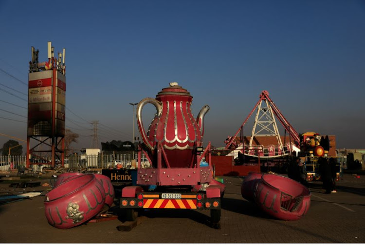 Giant tea cups from one of the rides at Tommy's World Fair lie dismantled as staff begin packing up after four days of deadly protests in Vosloorus.