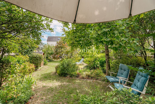 Lush garden with chairs and umbrella in this luxury house for sale in Vannes ($1,283,752 - 188 m²)