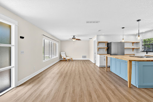 Open living room and kitchen with blue island in this luxury property for sale in Palm Coast ($343,000)