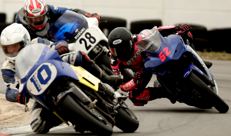 Glen Elliot on a Suzuki GSXR 750 (10), Jessica Howden on a Kawasaki (52) and Malcolm Burrows, also on a Suzuki GSXR 750 (28), get their knees down