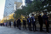 People line up to take a nucleic acid test for the coronavirus disease (COVID-19) at a testing booth near an office building in Central Business District (CBD) in Chaoyang district, Beijing, China November 15, 2022. 